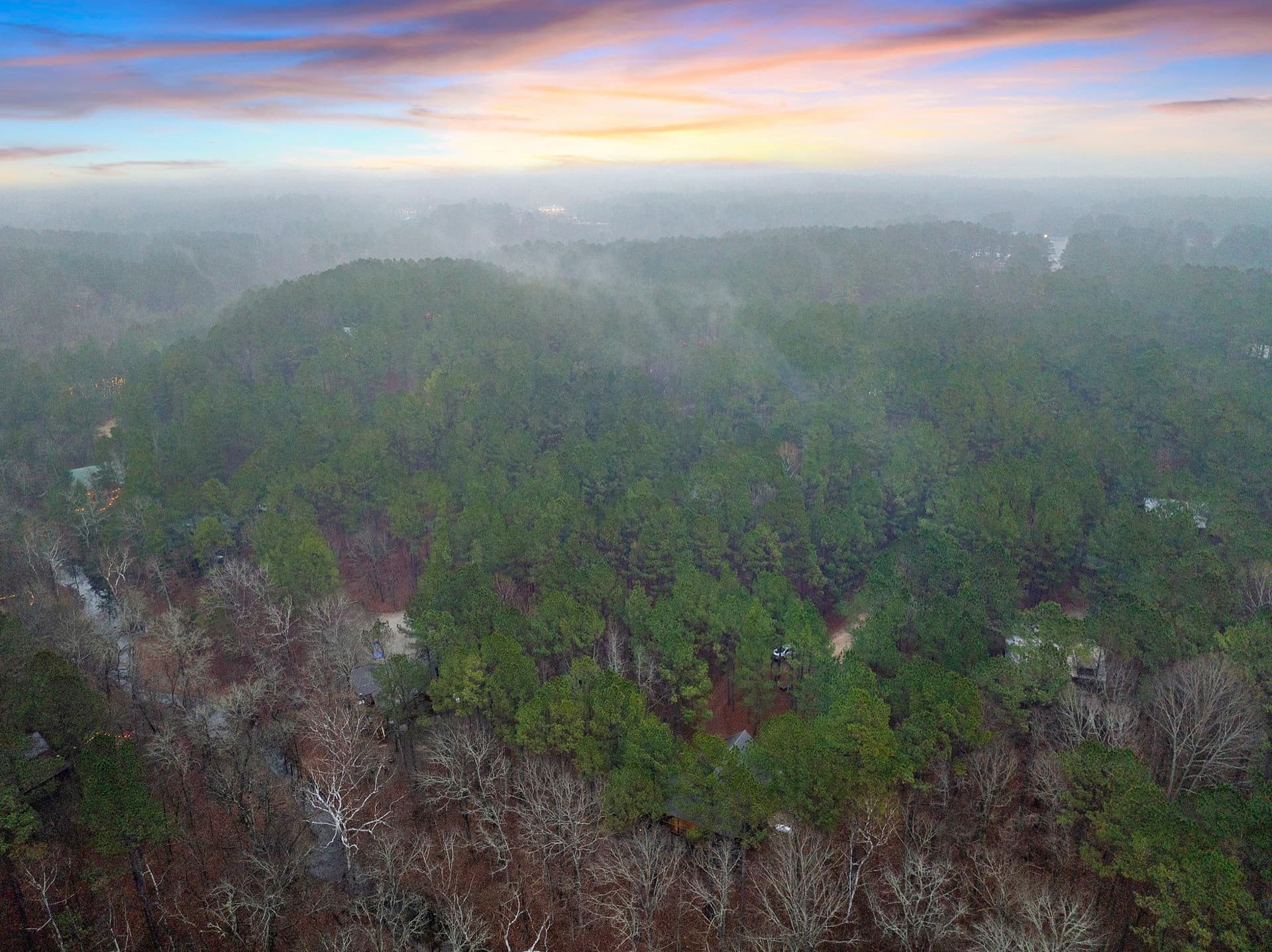 Mist over a forested ridgeline at sunrise near the lake corridor