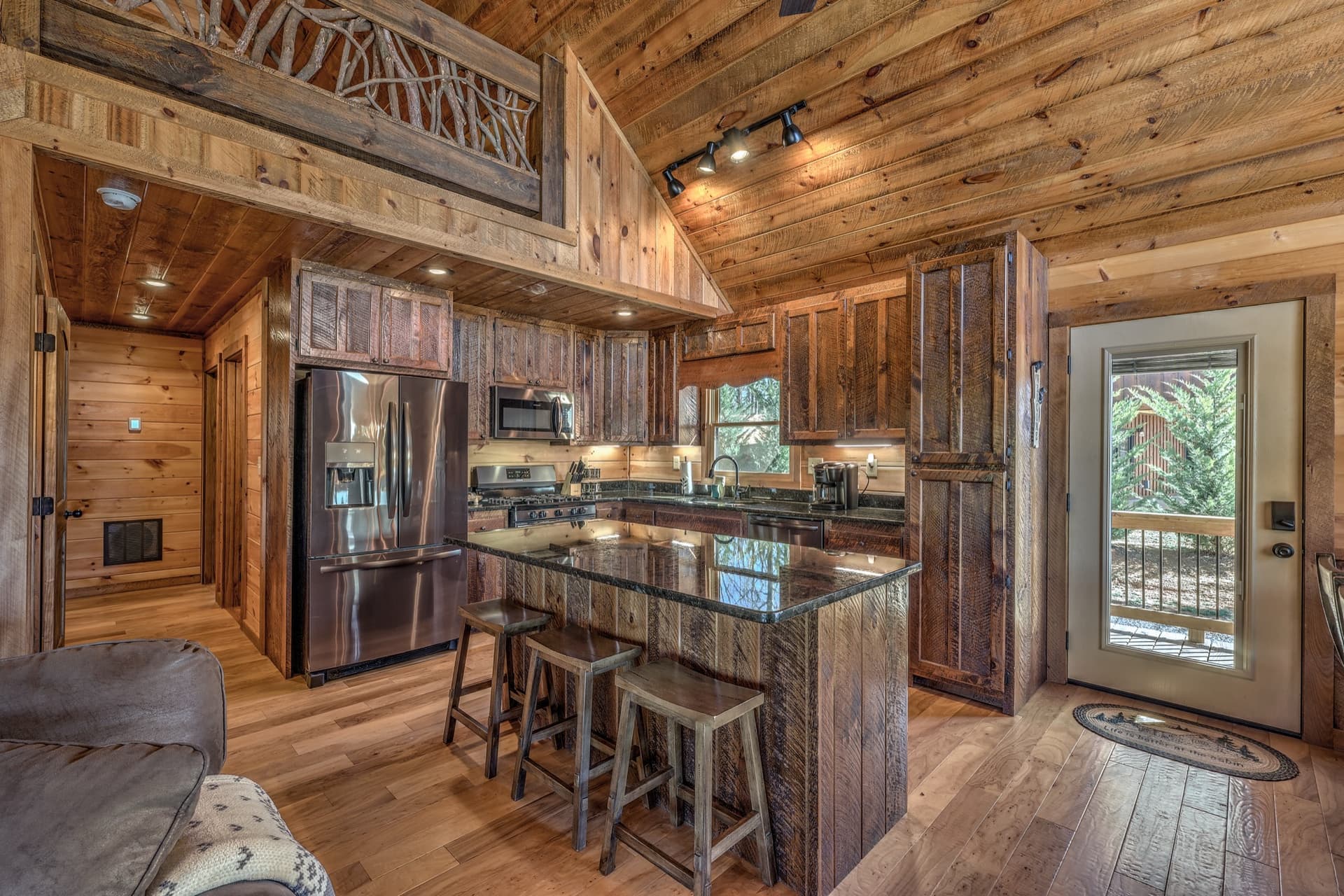 Chef's kitchen with a granite island and barstools at Bella Emelia, a couples cabin in Blue Ridge, GA